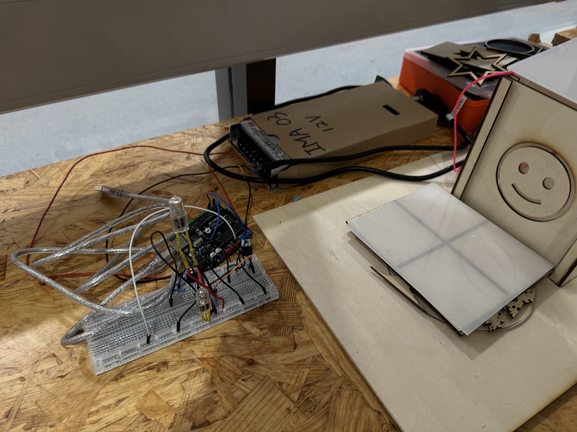 Breadboard circuit with a halogen bulb wired next to the partially assembled model