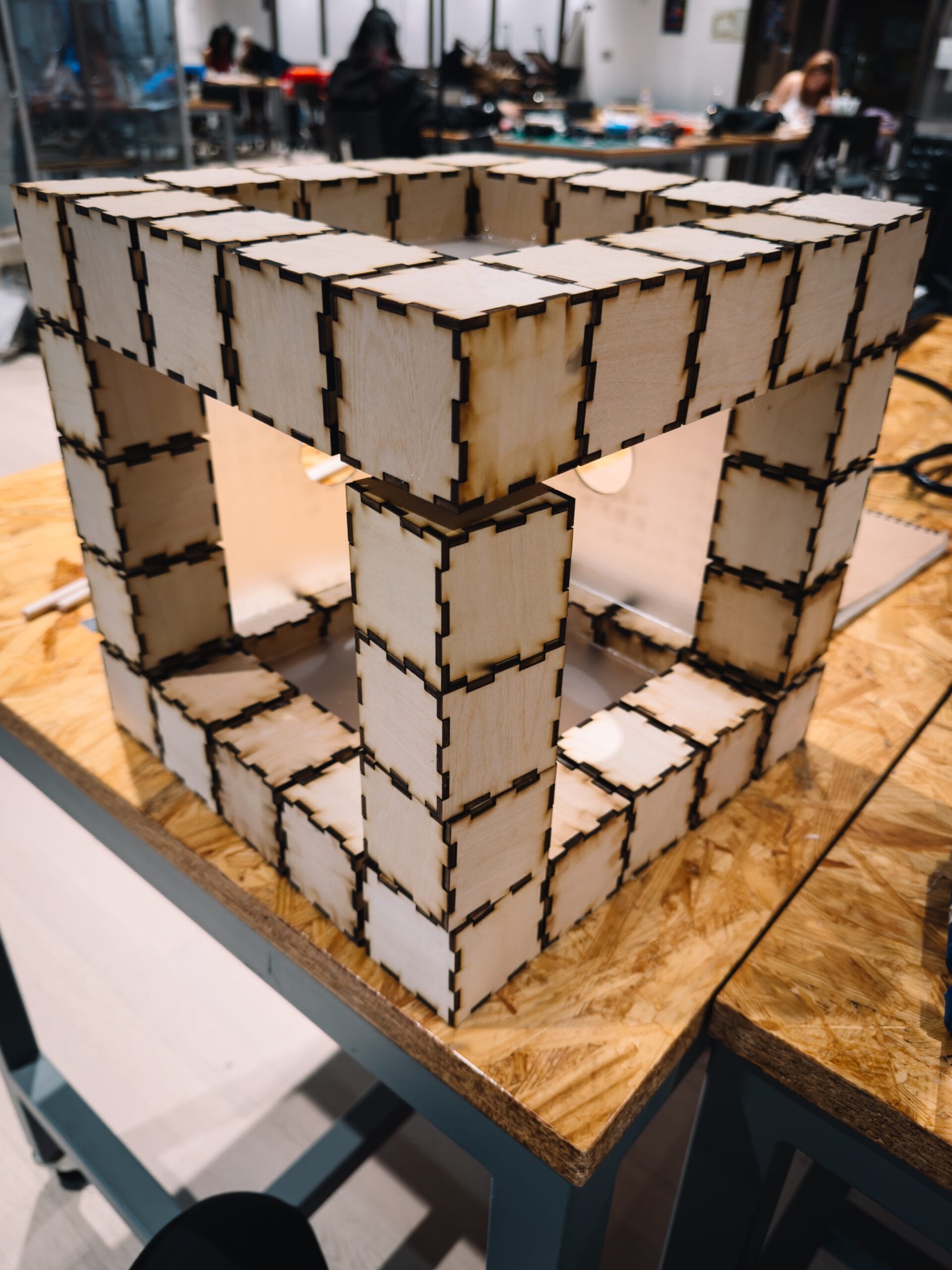 Skeletal frame of the cube built from interlocking laser-cut plywood blocks