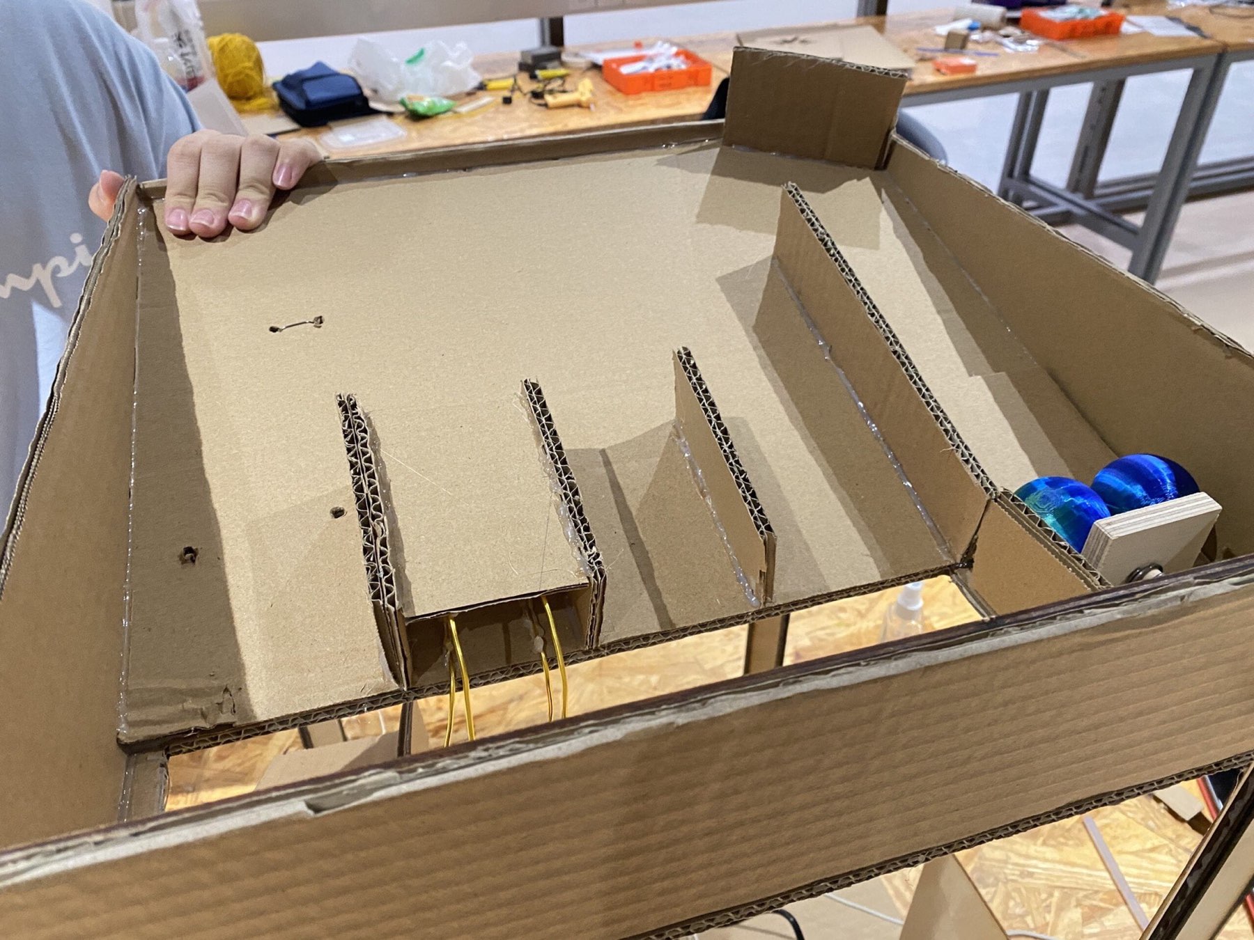 Cardboard sorting lanes under construction on the machine's top surface