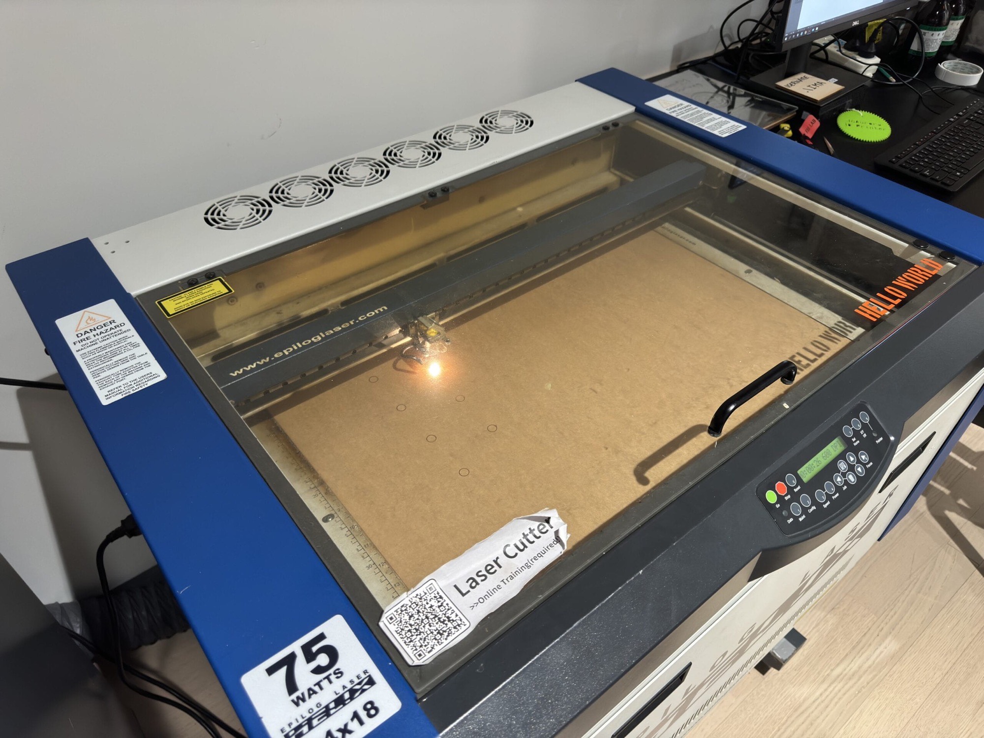 Laser cutter at work on boards for the machine