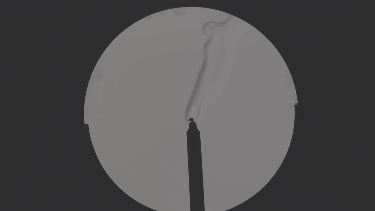 Invisible Currents - schlieren-style visualization of warm air rising from a candle as drifting ribbons of light