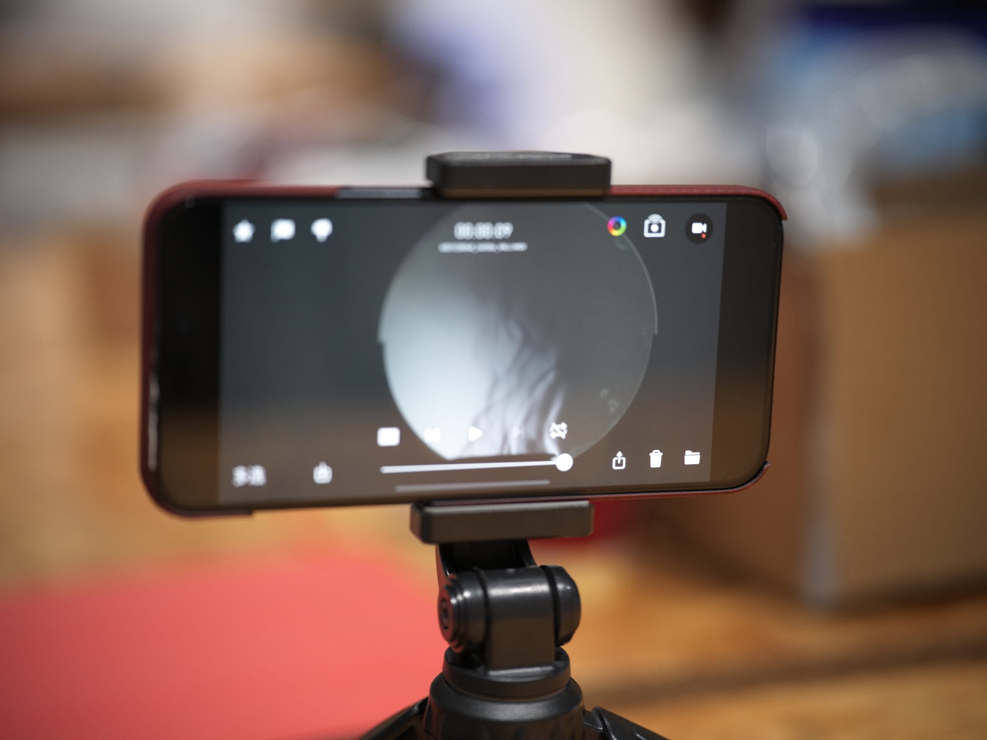 Smartphone mounted on a small tripod, its screen showing the circular mirror image with rising air currents
