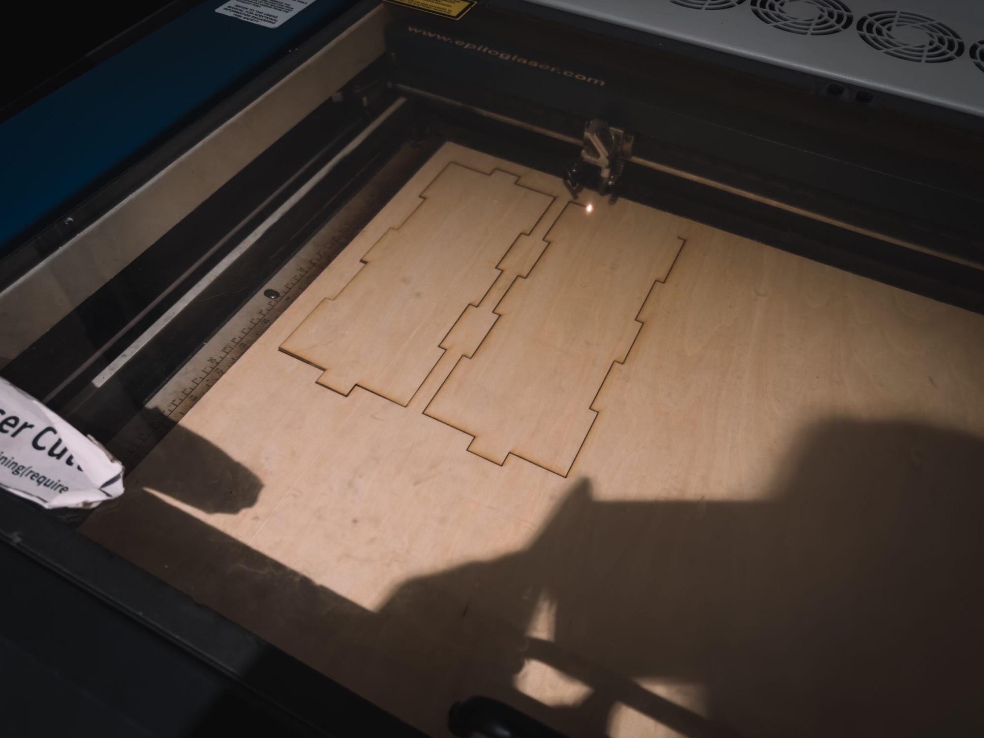 Laser cutter cutting plywood panels for the enclosure