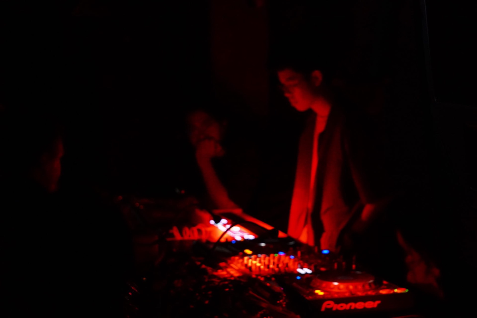 Boyan Peng performing at the MIDI setup under deep red light