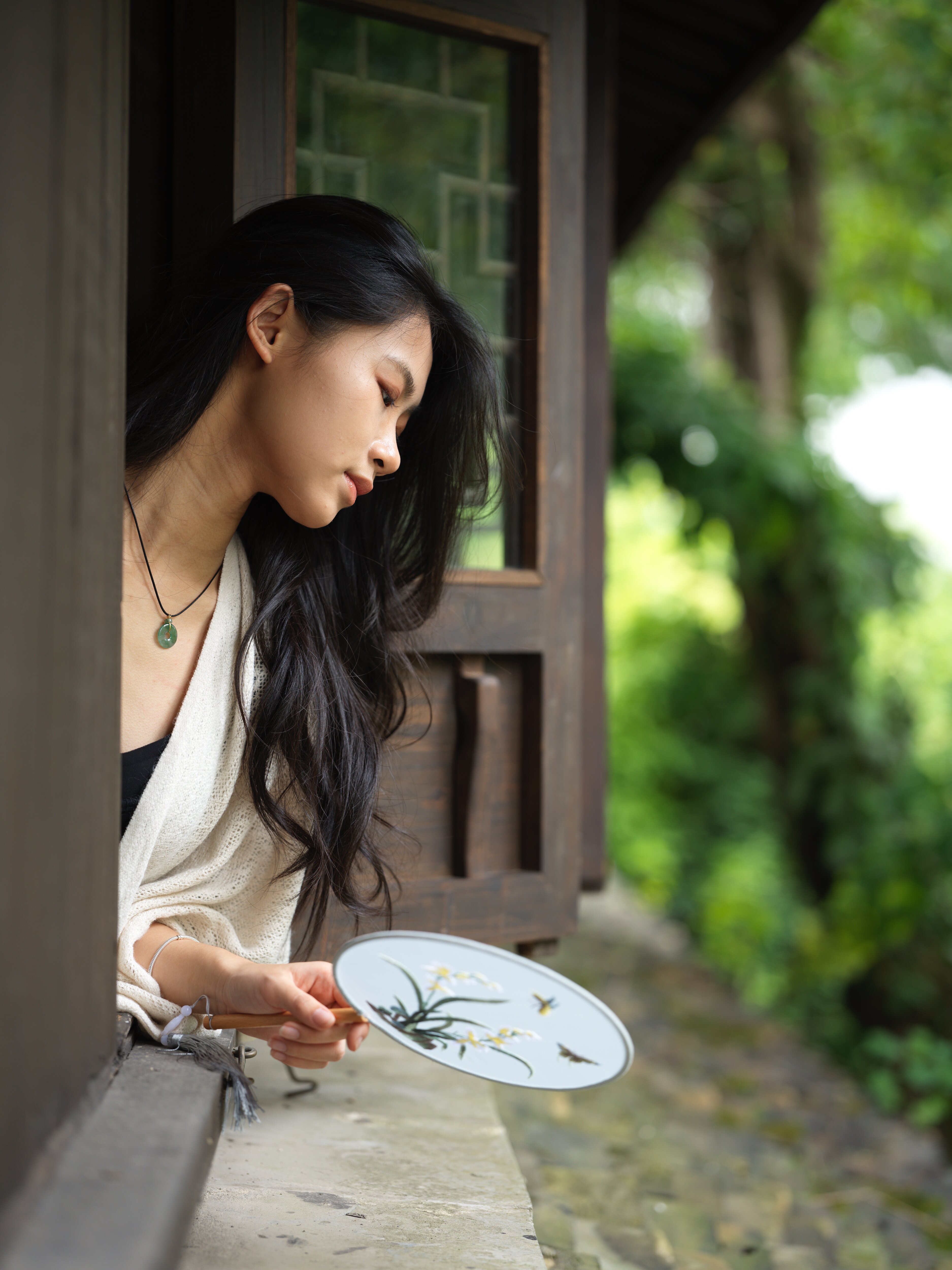Leaning from a timber window with a silk fan, Shaoxing, 2024