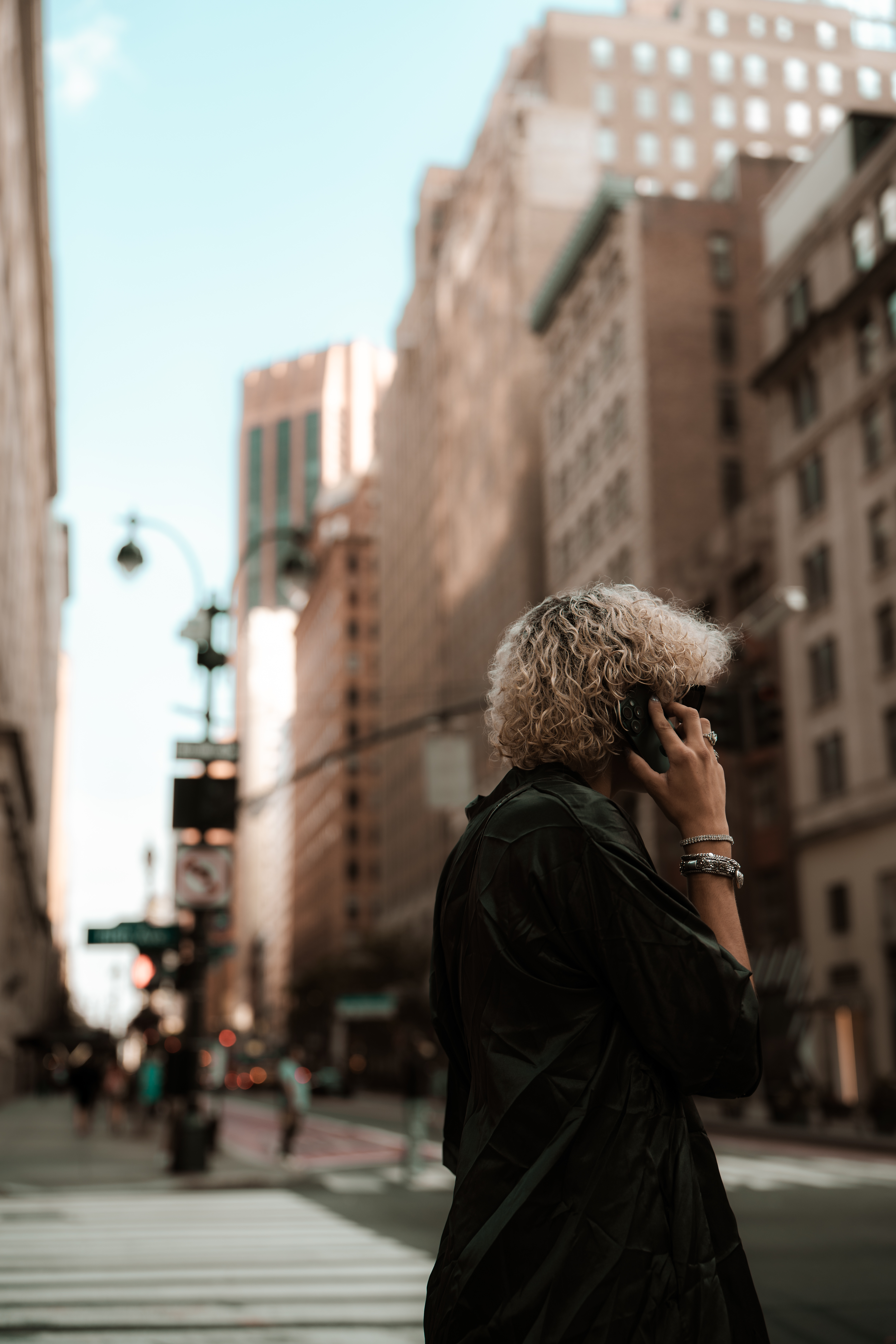 Woman in black coat with white hair on phone