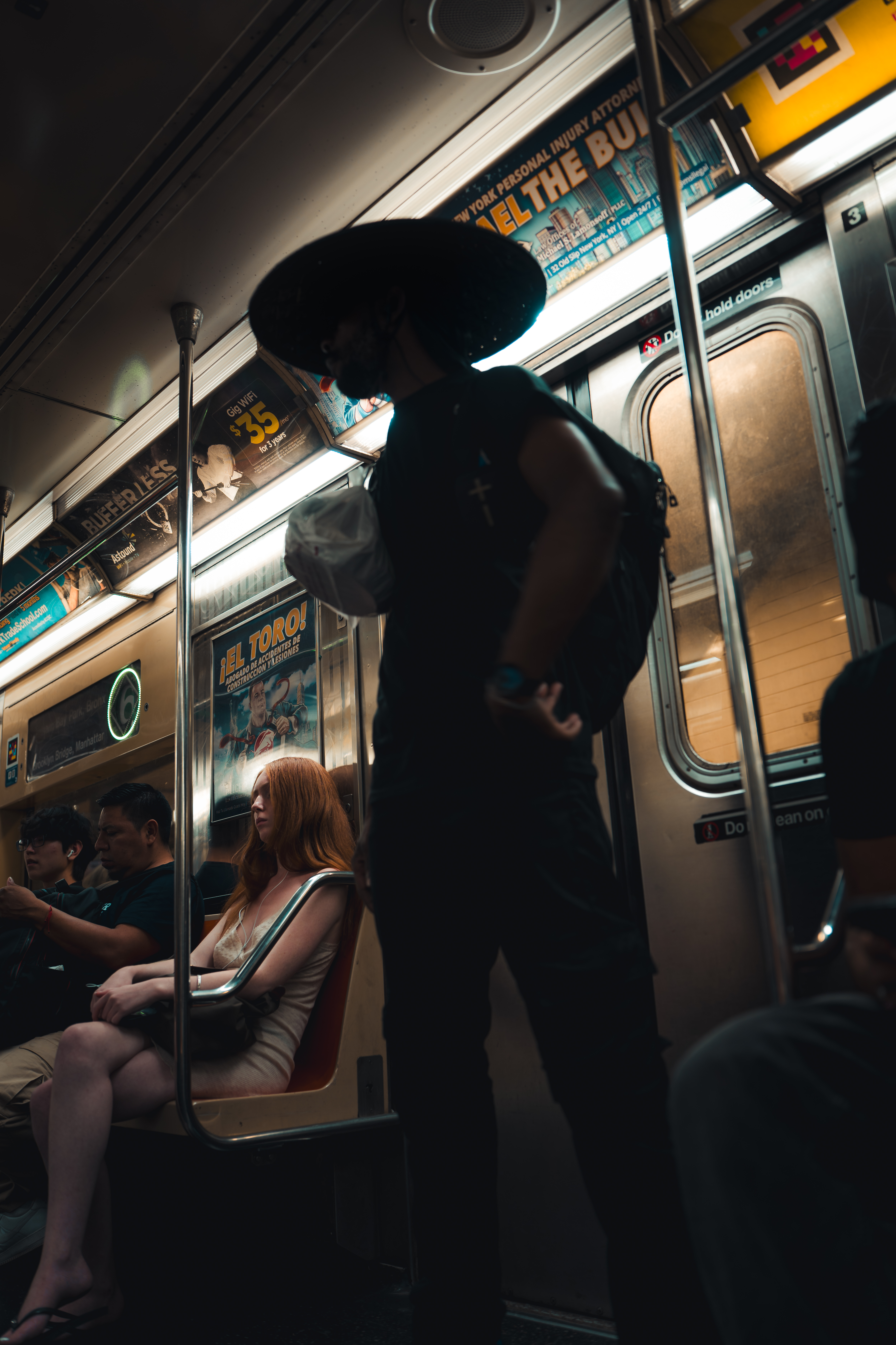 Man wearing straw hat on subway