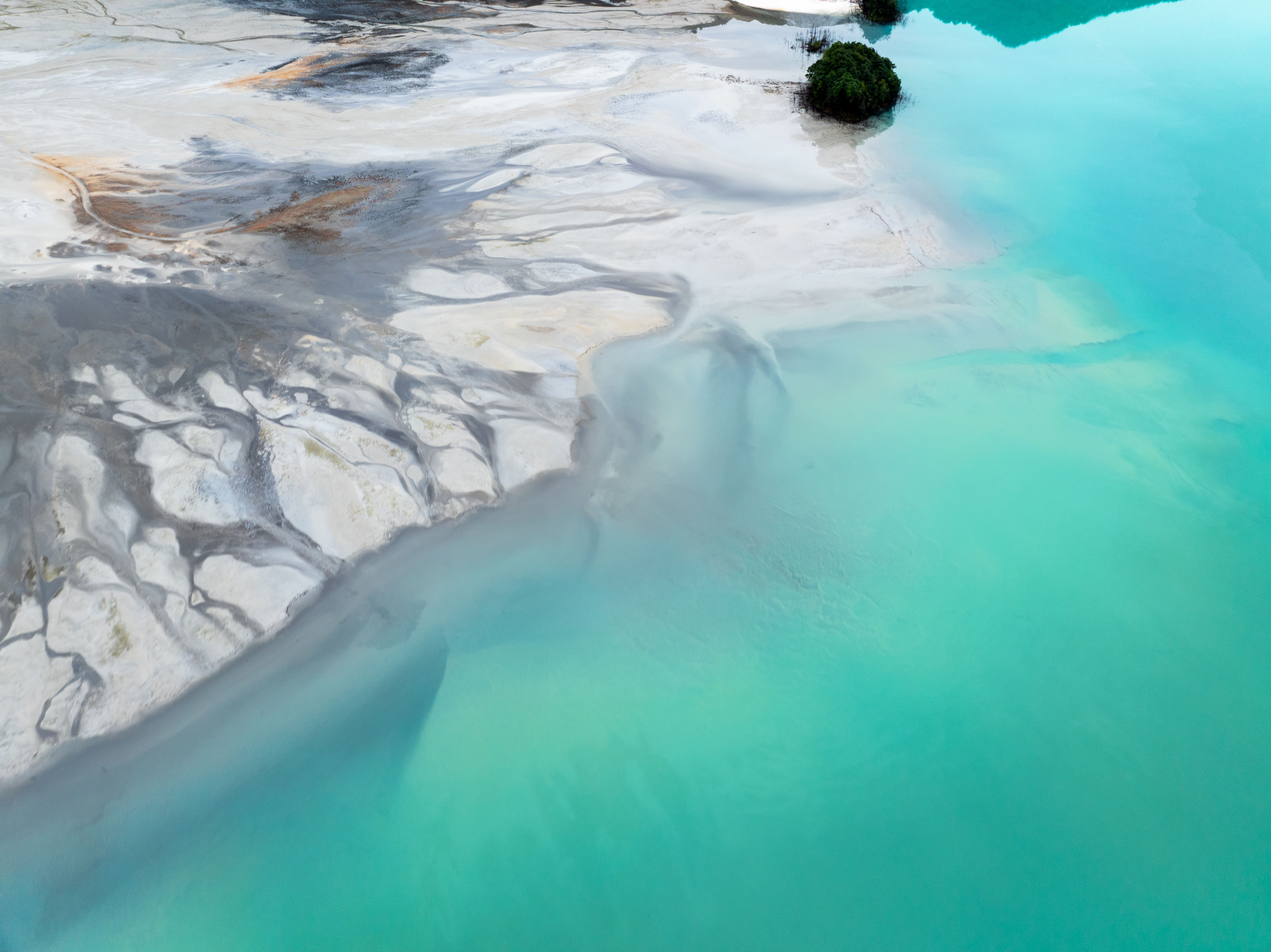 Aerial view of turquoise waters and white sands at Dexing Copper Mine tailings pond